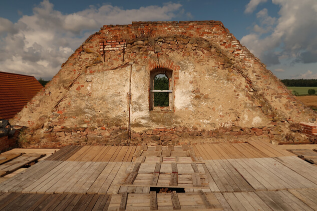 Západní štít sýpky s dosud patrným otiskem někdejší střechy kostela, 2023