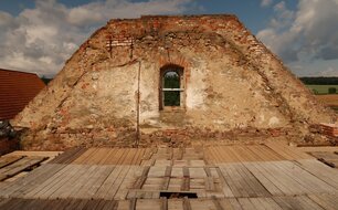 Západní štít sýpky s dosud patrným otiskem někdejší střechy kostela, 2023