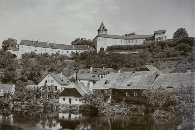 Rožmberk nad Vltavou, zástavba podhradí s objektem synagogy (uprostřed se čtyřmi vikýři na střeše), v pozadí nový zámek a věž Jakobínka. ÚDU AV ČR, Sbírka historické fotografie