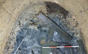 Soubor prken na povrchu fekálního sedimentu – pozůstatky dřevěné konstrukce latrín.