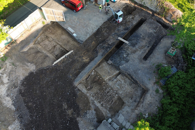 Detail poslední zkoumané linie společného hrobu č. 12 a 17 s kosterními ostatky padlých vojáků. Jsou uloženy v několika etážích střídavě hlavou k severu a k jihu. Severněji se podařilo zachytit individuální hroby východo-západní orientace (foto Egon Ditmar, 9. 5. 2025).